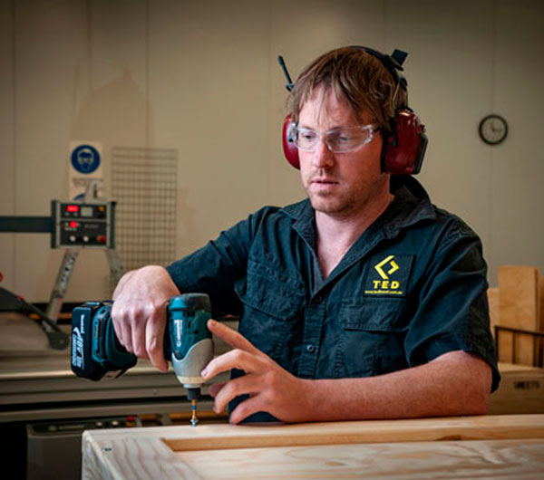 T.E.D. technician assembling a crate in the workshop
